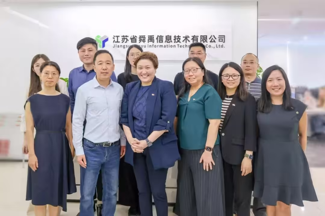 Group of approximately eleven people posing in front of the Jiangsu Sunyu Information Technology Co., Ltd. office sign in Chengdu, China.
